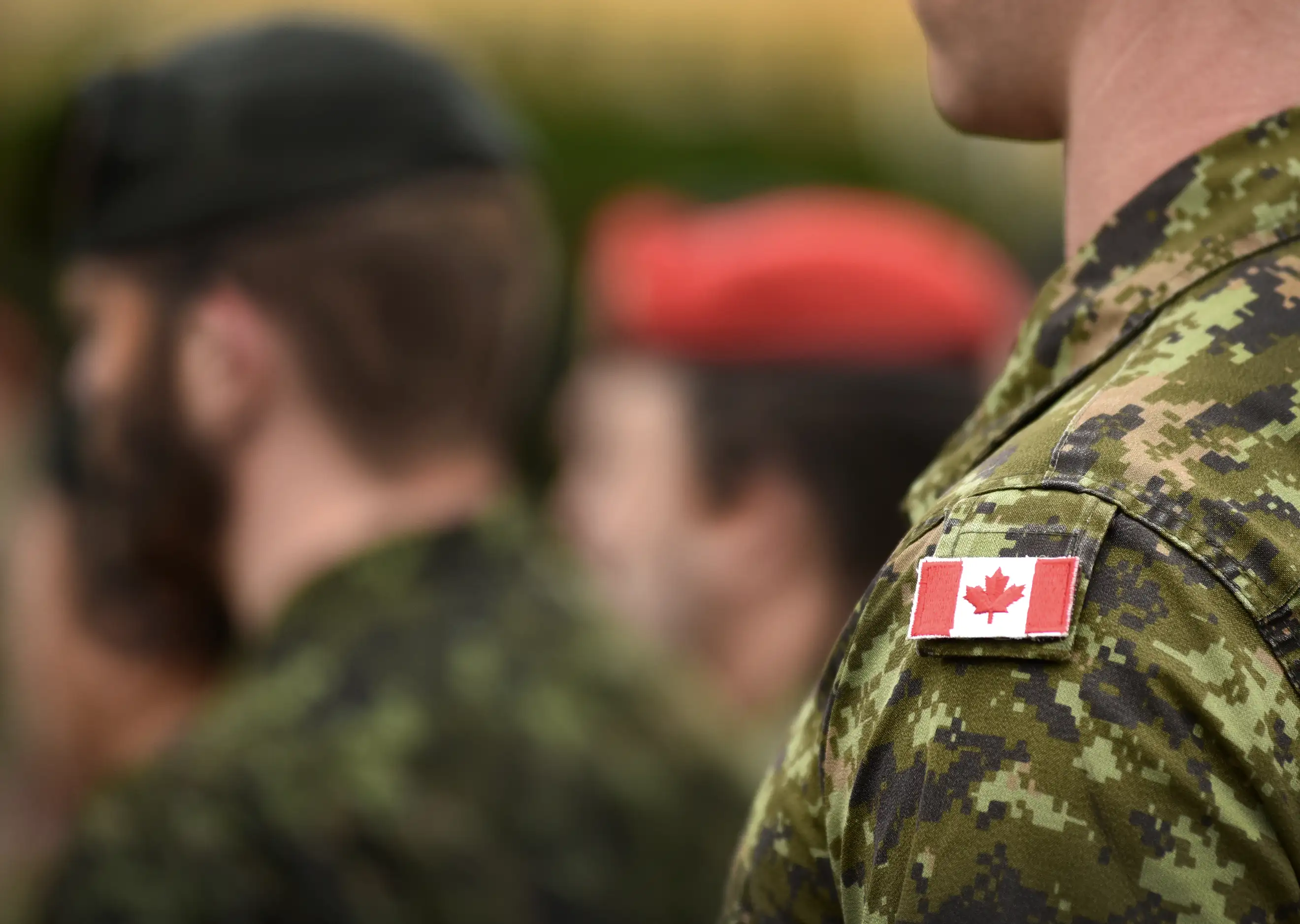 Soldier in uniform with a Canadian flag patch on shoulder